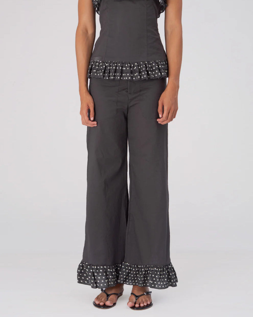 Māre Carmen Says brown polka dot pants with a relaxed fit and elastic waistband, styled with casual footwear and a top.